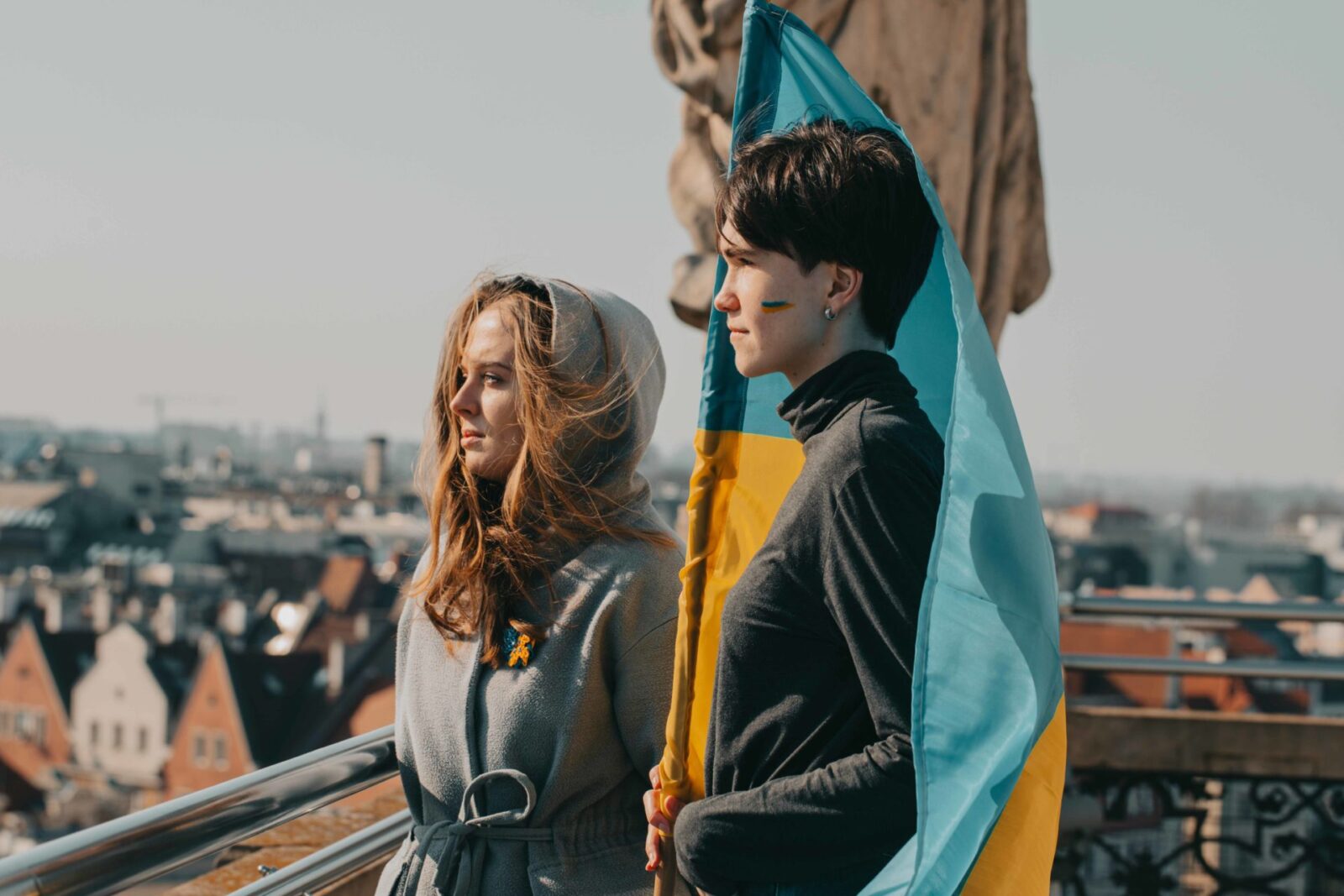 dwie młode kobiety z flagą Ukrainy na tle panoramy miasta